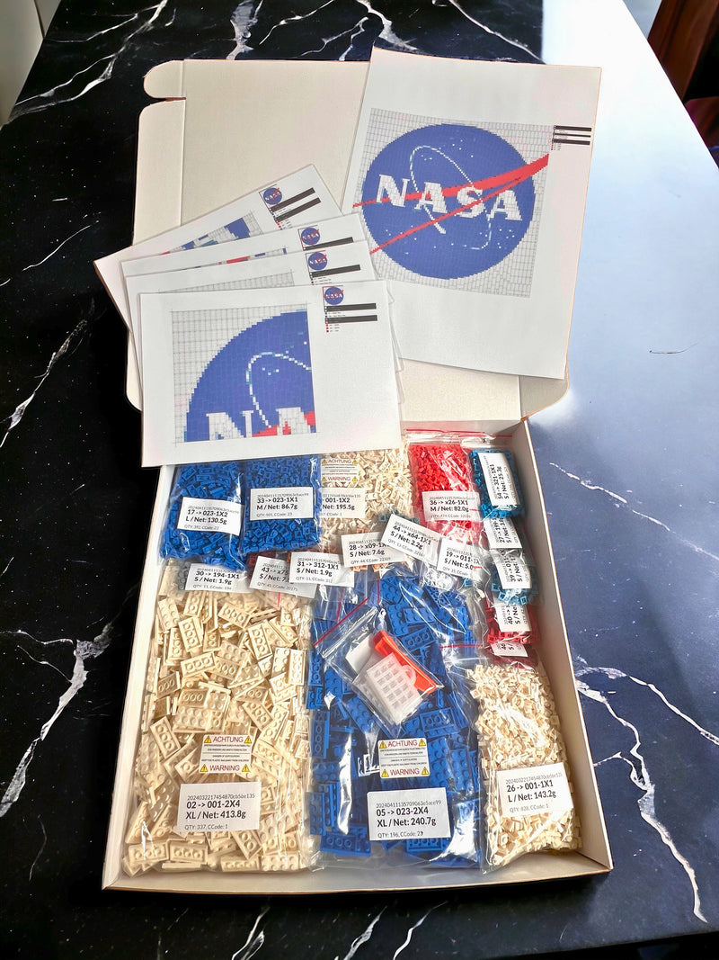 Box of NASA Brick Mosaic Design Kit items including stickers and labels on a marble surface